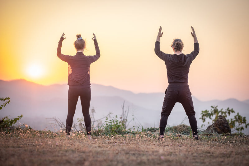 Two students practising Qigong at sunrise