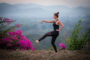 woman practicing qigong at sunset for recovery