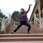 A woman on a staircase practicing Snake Qigong