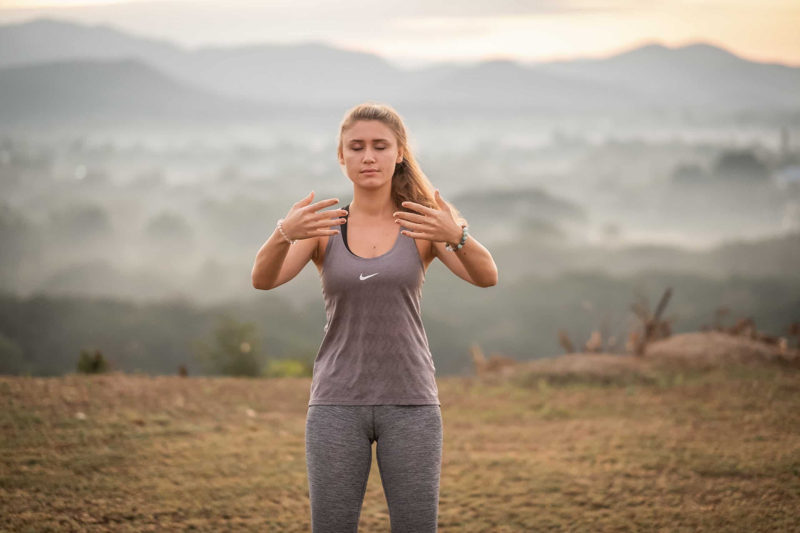 A woman practicing Qigong for Calming the Mind on top of the Mountain 